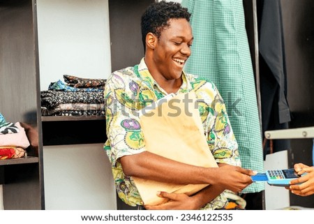 cheerful African merchant using a pos system for retail transactions