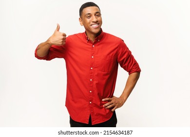 Cheerful African-American Guy In Red Shirt Showing Thumb Up Isolated On White. Smiling Multiracial Man Showing Approval Gesture At The Camera, Likes It