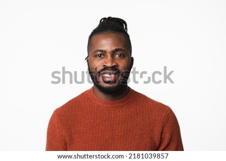 Cheerful african-american young man with dreadlocks wearing sweater looking at the camera with toothy smile isolated in white background