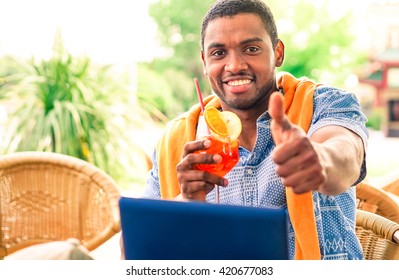 Cheerful afro american man thumb up sitting in beach bar cafe - Concept of relaxing travel holiday and successful lifestyle