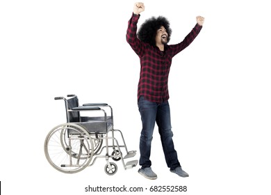 Cheerful Afro Man Standing Up From A Wheelchair Isolated On White Background