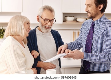 Cheerful Aged Couple Owners Meeting Real Estate Agent At Home