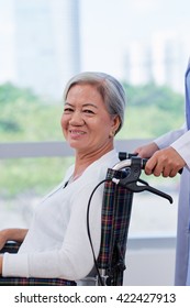 Cheerful Aged Woman In Wheelchair After Treatment In Hospital