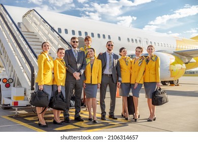 Cheerful Aircrew Standing Near Airplane At Airport