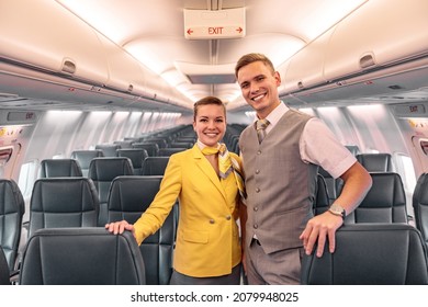 Cheerful airline workers standing in aircraft passenger salon