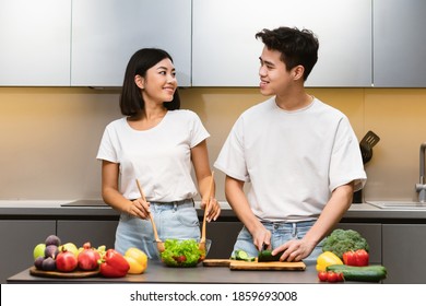 Cheerful Asian Couple Cooking Enjoying Dinner Preparation And Conversation Standing In Modern Kitchen At Home. Weekend Leisure, Healthy Food Recipes, Family Nutrition Concept