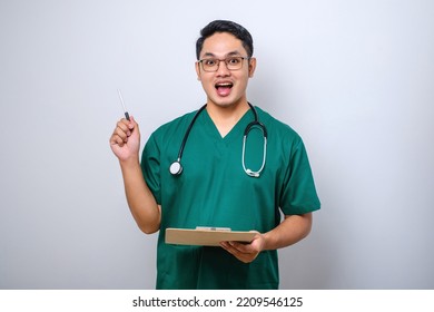 Cheerful Asian Male Nurse Or Doctor Having Good Idea While Holding Clipboard Standing Over White Background