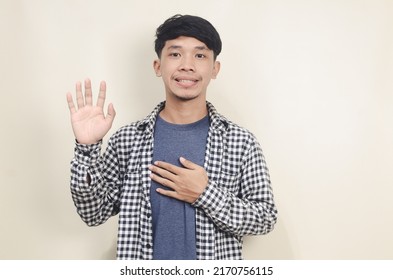 Cheerful Asian Man Waving To Say Hello On Isolated Background