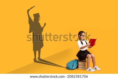 Cheerful Asian Schoolgirl Reading, Sitting On Book Stack, Shape Of Female In Graduation Costume Over Yellow Background, Kid Dreaming About Master Degree, Conceptual Image, Panorama