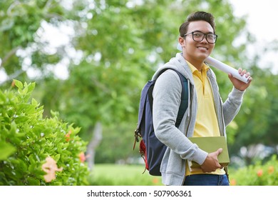 Cheerful Asian Student With Books And Blueprint