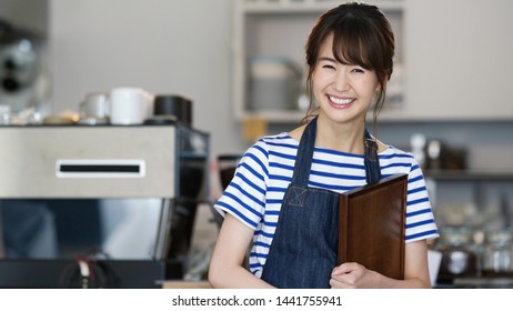 Cheerful asian waitress in cafe.