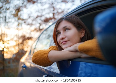 Cheerful asian woman in a car on sunset. the idea and concept of travel, discovery and recreation holiday
