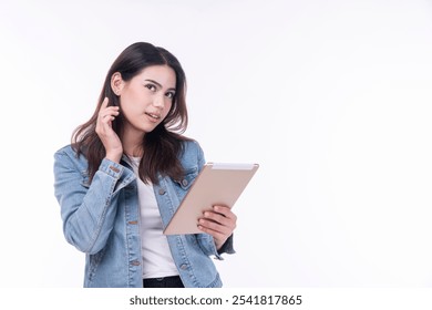 Cheerful asian woman denim jacket holding tablet thinking creative idea standing over isolated white background. Student young girl holding hand under chin education online tablet.Lifestyle technology - Powered by Shutterstock