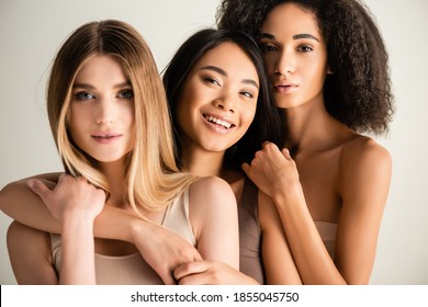 Cheerful Asian Woman Hugging Blonde Model Near African American Friend Isolated On White