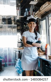 Cheerful Asian Woman Standing With Crossed Arms In Food Truck 