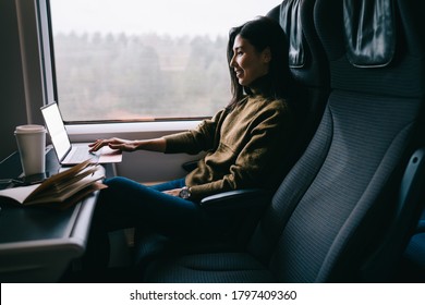 Cheerful asian woman traveler enjoying watching movie on laptop computer in wagon satisfied with wireless connection, smiling 20s female reading news working remotely on business trip in train - Powered by Shutterstock