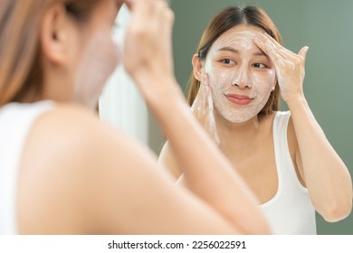Cheerful asian young woman, beauty girl hand applying foam cleanser for washing on her face, clean fresh healthy skin care, exfoliation scrub soap with cleansing product. Skincare spa relax concept.