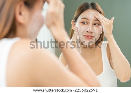 Cheerful asian young woman, beauty girl hand applying foam cleanser for washing on her face, clean fresh healthy skin care, exfoliation scrub soap with cleansing product. Skincare spa relax concept.