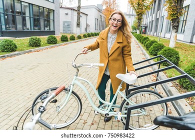 cheerful attractive elegant woman with bicycle in city - Shutterstock ID 750983422
