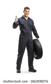 Cheerful Auto Mechanic Worker Holding A Car Tire And Showing Thumbs Up Isolated On White Background