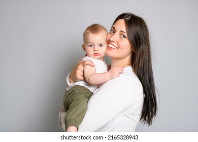 A Cheerful Baby Boy Toddler With His Mother On White Studio Background