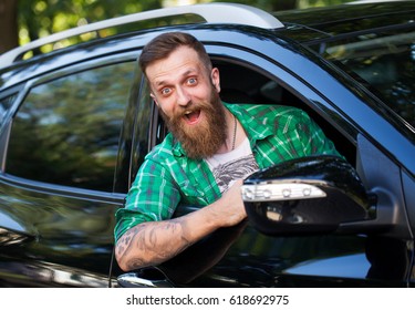 Cheerful bearded man in the car.