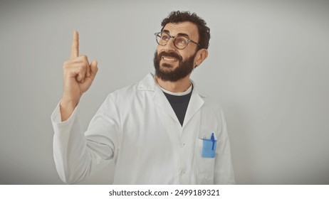 A cheerful bearded man in a lab coat pointing up isolated against a white background. - Powered by Shutterstock