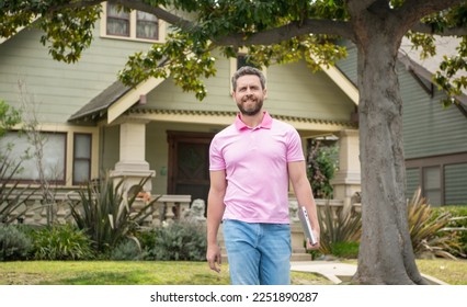 cheerful bearded man real estate agent selling or renting house walk with computer, neighborhood - Shutterstock ID 2251890287