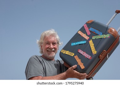 Cheerful Bearded Senior Man Holding His Suitcase Ready To Traveler For Summer Vacation  - Enjoying Lifestyle And Freedom Concept