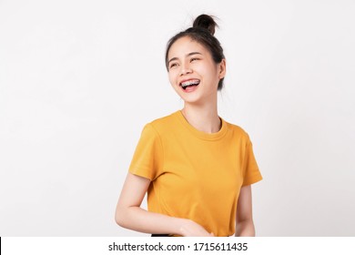 Cheerful beautiful Asian woman in a yellow shirt and stand on white background.