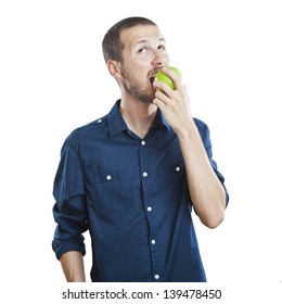 Cheerful beautiful man eating apple, isolated over white background