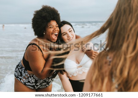 Cheerful beautiful plus size women at the beach