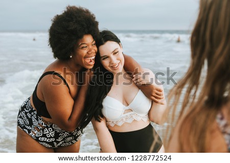 Cheerful beautiful plus size women at the beach