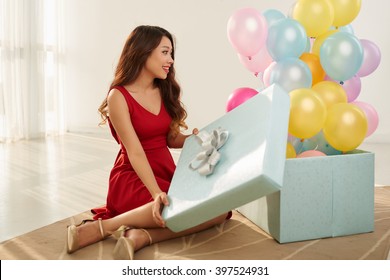 Cheerful Beautiful Woman Opening Gift Box Full Of Balloons