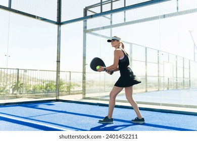 Cheerful beautiful woman smiling while having fun enjoying playing a padel tennis match looking happy - Powered by Shutterstock