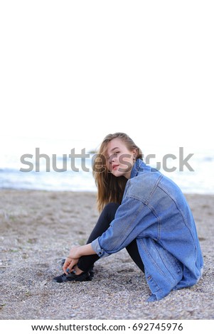 Similar – Young woman sits at the Baltic Sea beach