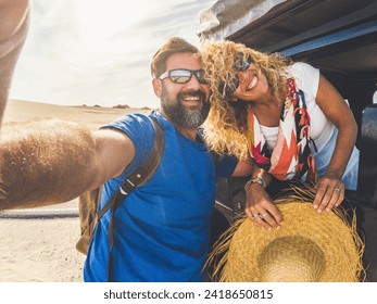 Cheerful beautiful youth adult caucasian couple enjoy and take a slefie picture with them and the car with tent on the roof - alternative vehicle for vacation and happy people together free - Powered by Shutterstock