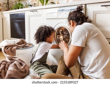 Cheerful Black Family: Kid Son Helping Father At Linen In Basket While Doing Laundry Near Washing Machine In Flight Kitchen In Weekend At Home  