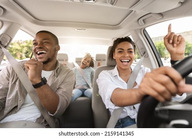 Cheerful Black Family Singing Riding New Car Having Fun Enjoying Road Trip On Vacation. Parents And Daughter Traveling By Automobile In Summer. Selective Focus - Shutterstock ID 2159141345