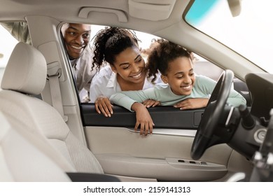 Cheerful Black Family Of Three Buying New Car, Looking Through Window At Auto Interior Choosing Luxury Automobile In Dealership. Vehicle Rent And Purchase Concept - Shutterstock ID 2159141313