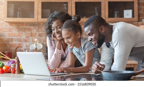 Cheerful Black Family Using Laptop At Kitchen, Looking For Healthy Food Recipe, Panorama With Copy Space