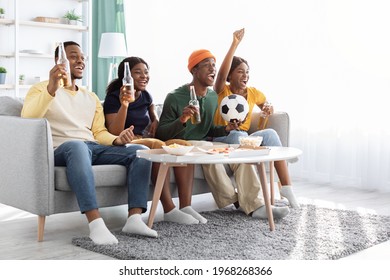 Cheerful Black Friends Young Men And Women Football Fans Watching Game At Home, Sitting On Couch In Living Room, Drinking Beer, Raising Hands Up And Screaming, Celebrating Goal, Copy Space