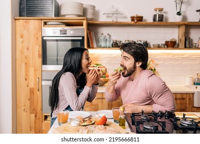 Cheerful black woman and her boyfriend having delicious breakfast in the kitchen at home. - Powered by Shutterstock