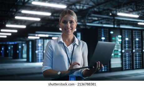 Cheerful Blonde Female IT Specialist Using Tablet Computer in Data Center, while Smiling to the Camera. Successful Businesswoman, e-Business Entrepreneur Concept - Powered by Shutterstock