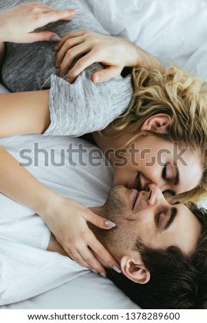 Similar – Young couple in love embracing lying over a bed