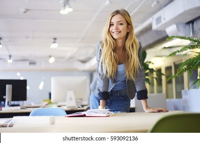 Cheerful Blonde Young Female Student Of IT School Preparing For Quiz Reading Notes And Information For Copybook Feeling Confident Before Testing Begins Standing In University Computer Classroom 