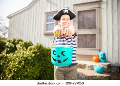 Cheerful Boy Holding A Halloween Teal Bucket With Trinkets. Teal Pumpkin Project. 