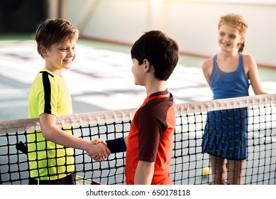 Cheerful boys shaking hands before playing tennis - Powered by Shutterstock