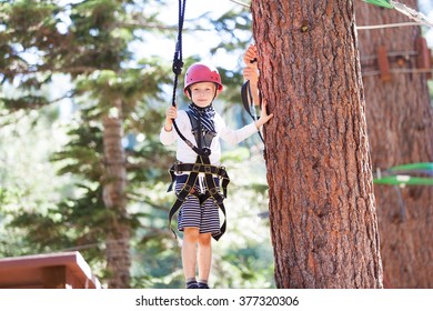 Cheerful Brave Boy Enjoying Climbing At Treetop Adventure Park
