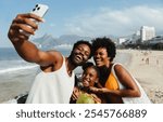 A cheerful Brazilian family enjoys a sunny day at a beach in Rio de Janeiro, capturing the moment with a selfie. The scene showcases joy and togetherness, with the iconic cityscape in the background.